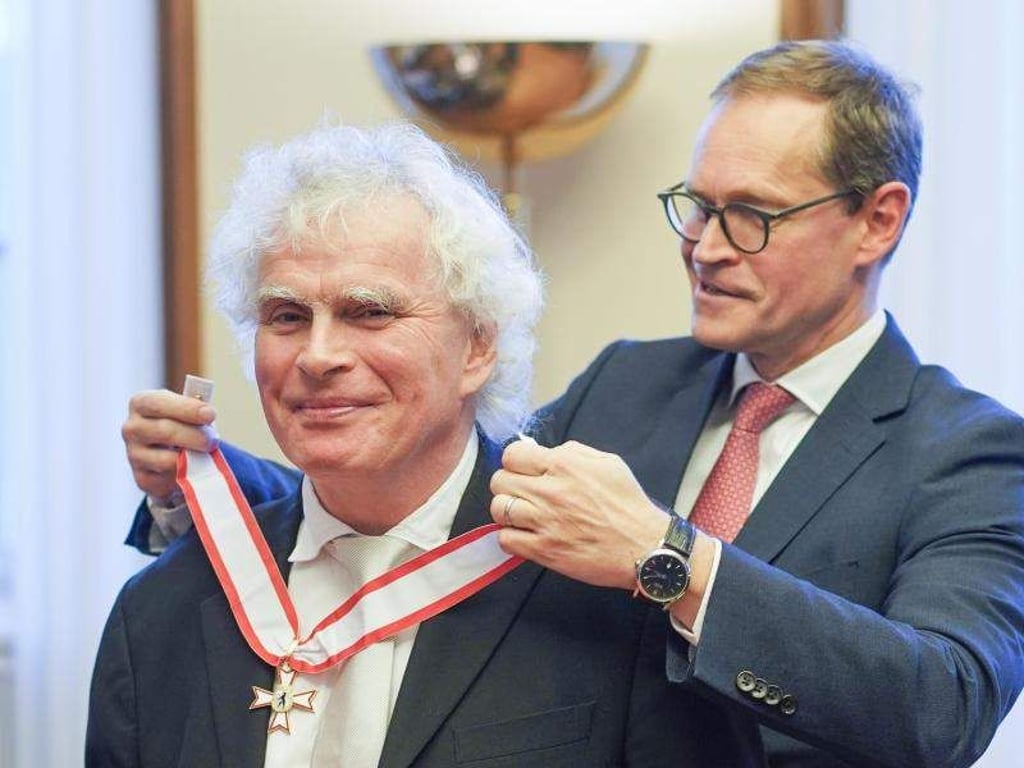 Michael Müller, Berlins Regierender Bürgermeister, verleiht Sir Simon Rattle den Berliner Verdienstorden. Foto: Jörg Carstensen