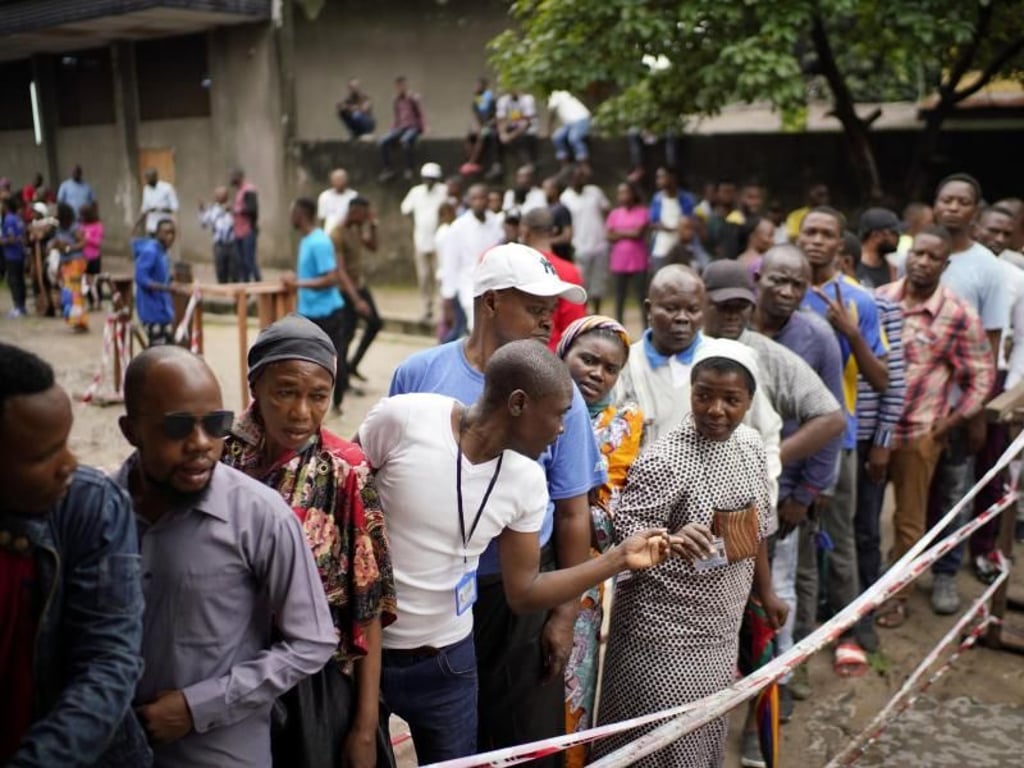 Wähler warten vor einem Wahllokal in Kinshasa auf die Abgabe ihres Stimmzettels. Foto: Jerome Delay/AP