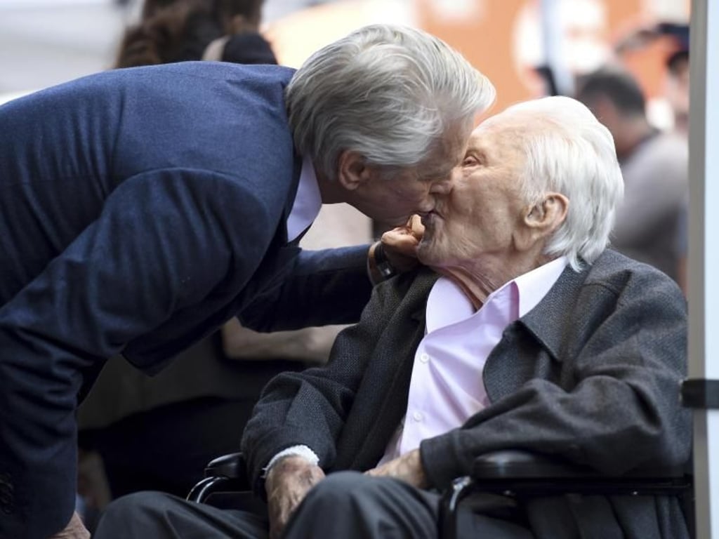 Ein Küsschen für Kirk Douglas von seinem Sohn Michael (l). Foto: Chris Pizzello/Invision/AP