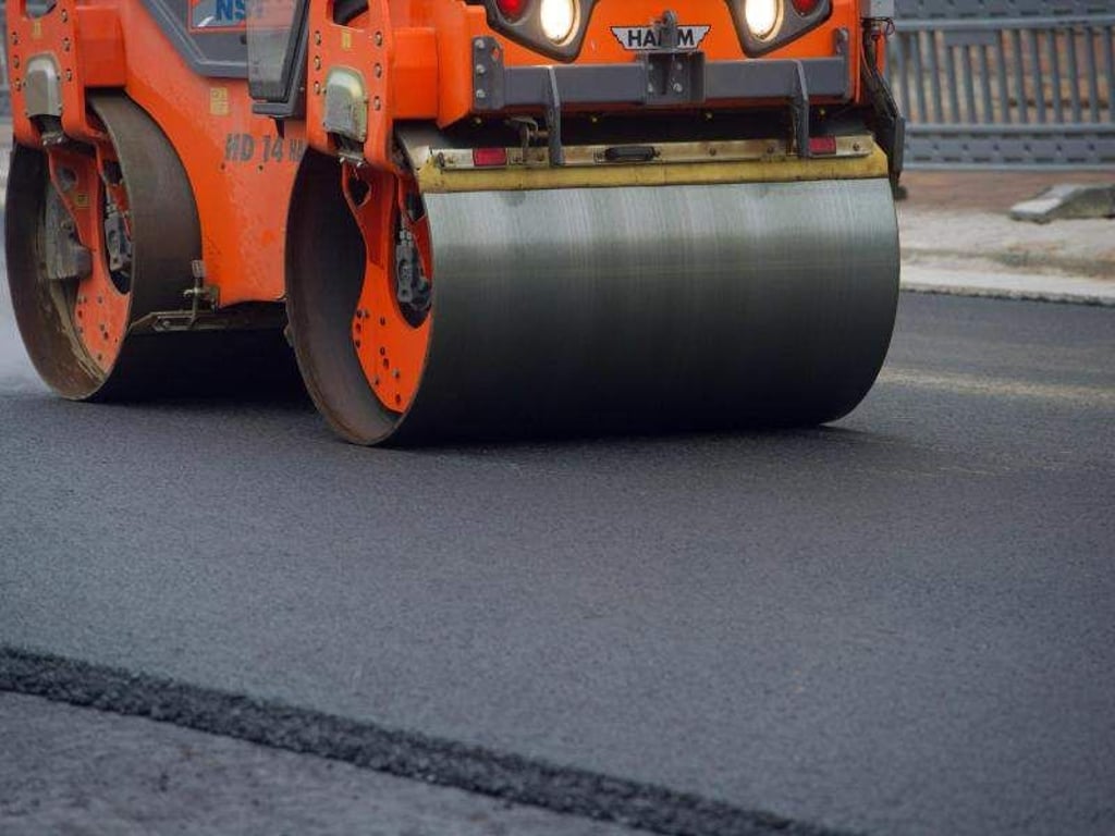 Auf einer Baustelle wird eine neue Asphaltdecke aufgebracht. Foto: Stefan Sauer/Archiv