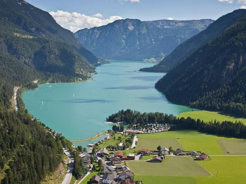 Türkis schimmert das Wasser des Achensees - da wollen so manche lieber am Ufer einen Drink genießen als aufs Surfbrett zu steigen. Foto: Tourismusverband Achensee/dpa-tmn