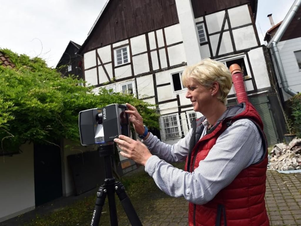 Auch die Außenhülle lässt sich abbilden: Birgit Kostner von der Firma Drücker&Schnitger Gbr scannt die Fassade eines älteren Fachwerkhauses. Foto: Caroline Seidel/dpa-tmn
