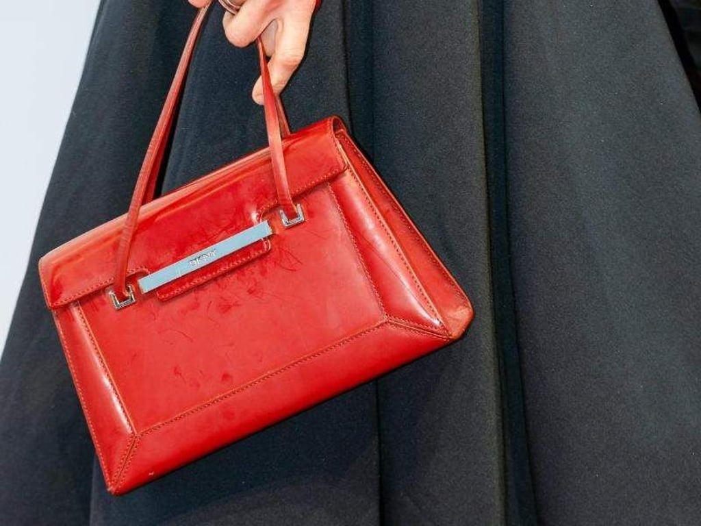 Eine rote Handtasche peppt das schwarze Kleid auf. Foto: Markus Scholz/dpa