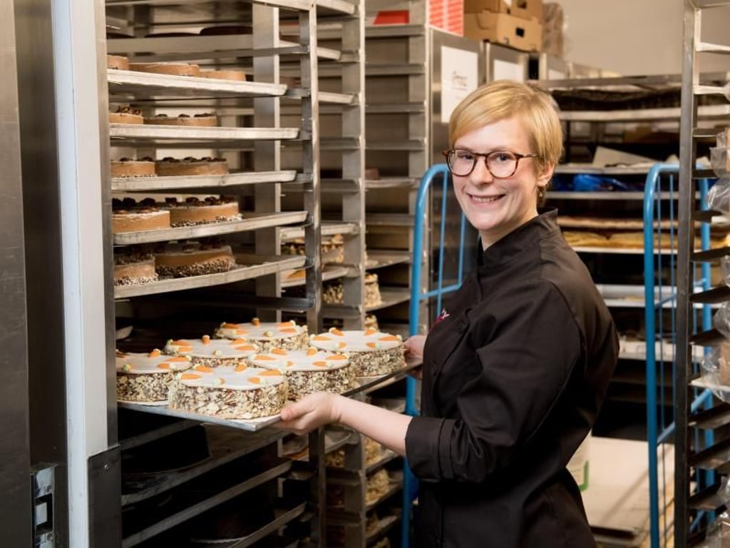 Ein halbes Dutzend Torten zu tragen, das ist anstregend - gehört aber zum Beruf: Hier schiebt Sophie Meier ein volles Blech in einen Wagen im Kühlraum ihres Ausbildungsbetriebs. Foto: Tobias Hase