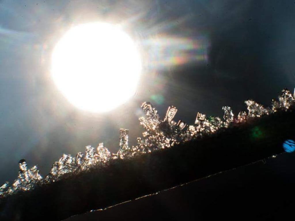 Eiskristalle glitzern im Lichte der aufgehenden Sonne. Foto: Julian Stratenschulte/Archiv