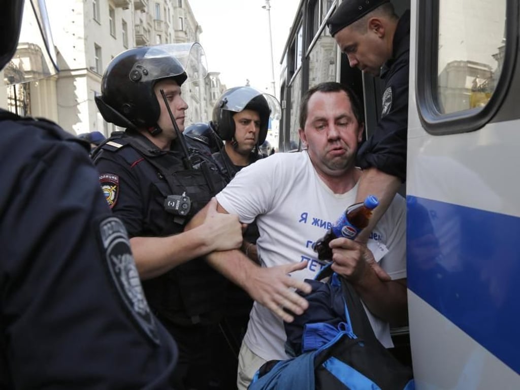 Polizeibeamte nehmen einen Mann fest. Foto: Alexander Zemlianichenko/AP