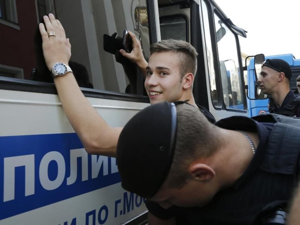 Polizeibeamte tasten einen festgenommenen Demonstranten ab. Foto: Alexander Zemlianichenko/AP