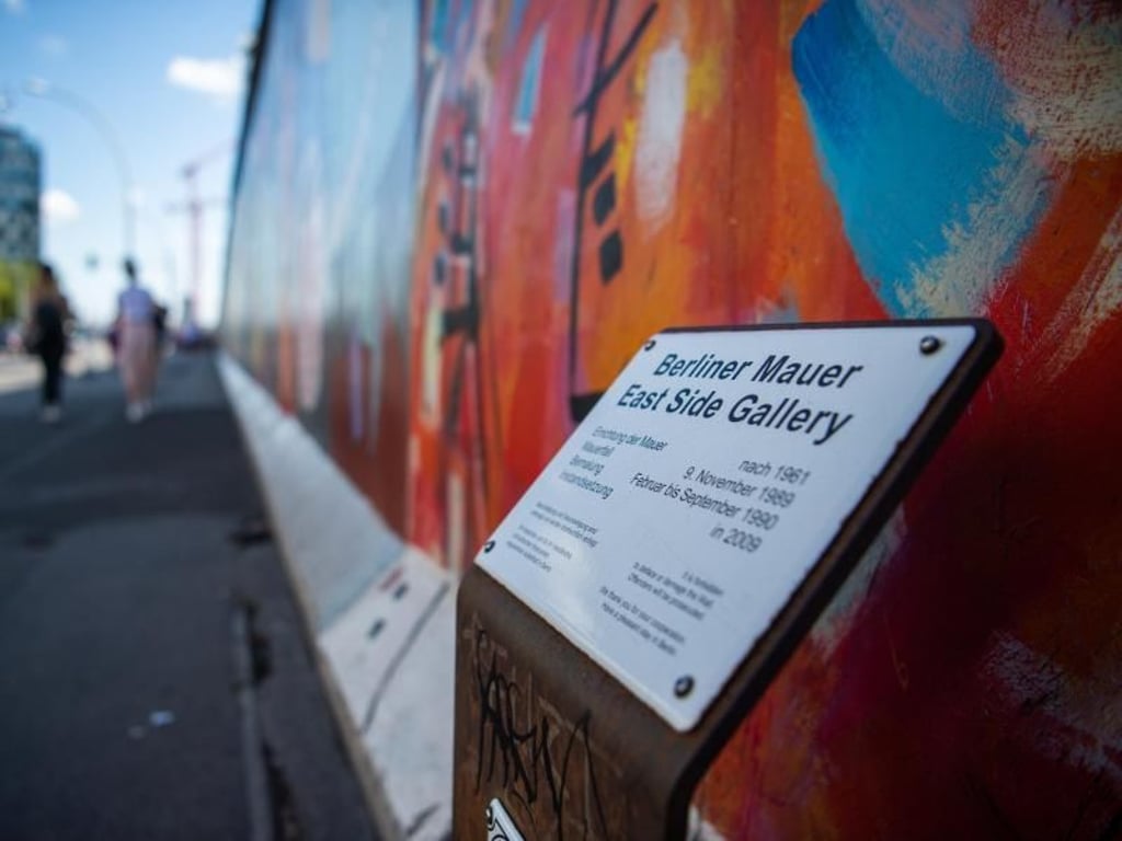 Ein Schild erklärt die historischen Hintergründe der East Side Gallery. Foto: Arne Immanuel Bänsch