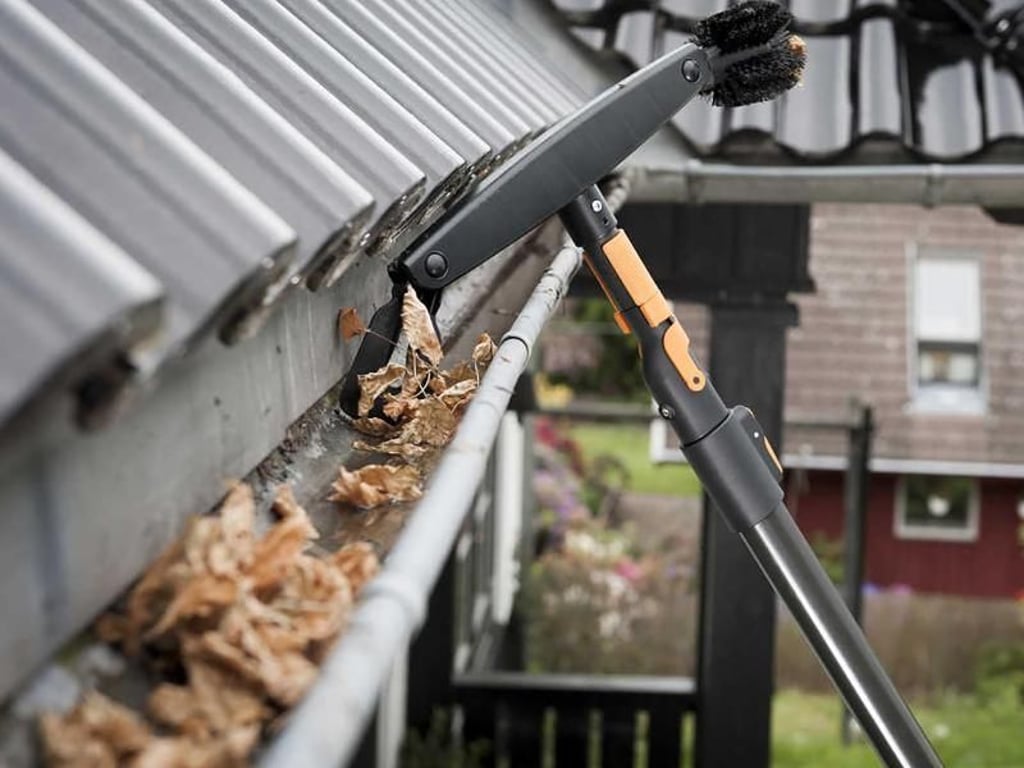 Mit Teleskopstangen lässt sich das Laub aus den Dachrinnen holen - und zwar sicher vom Boden aus. Foto: Fiskars/DIY Academy/dpa-tmn