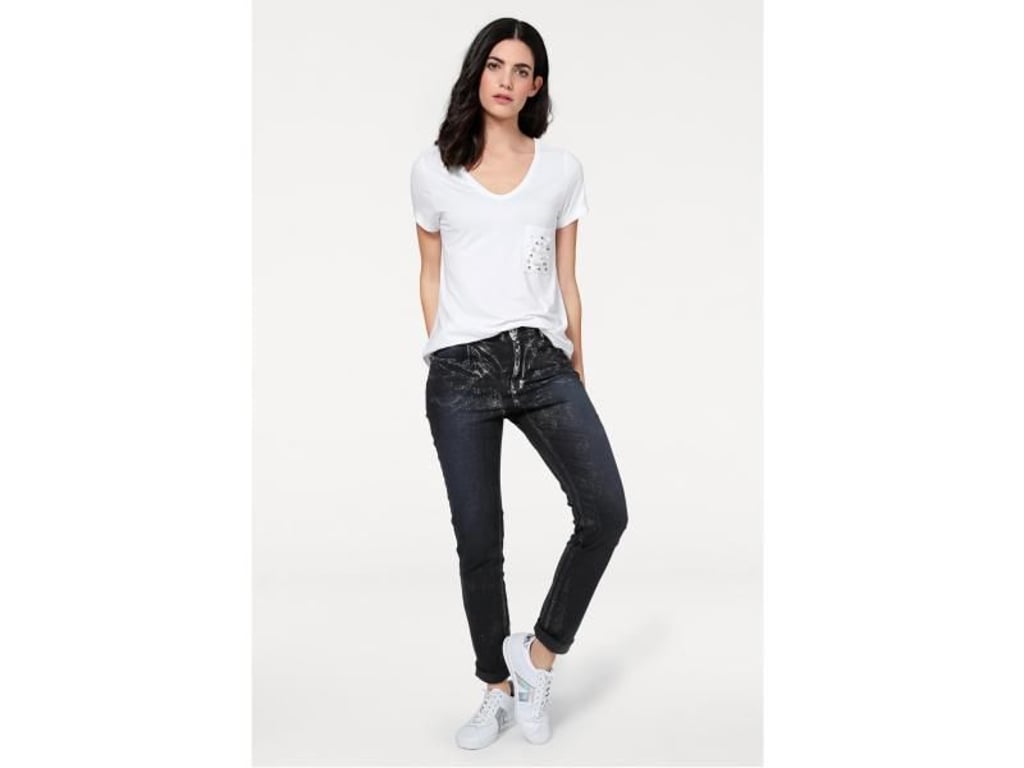 Auch Jeans gibt es mit Metallic-Effekt - wie beispielsweise Heine zeigt (Jeans ca. 60 Euro, Shirt ca. 30 Euro, Sneaker ca. 60 Euro). Foto: Heine