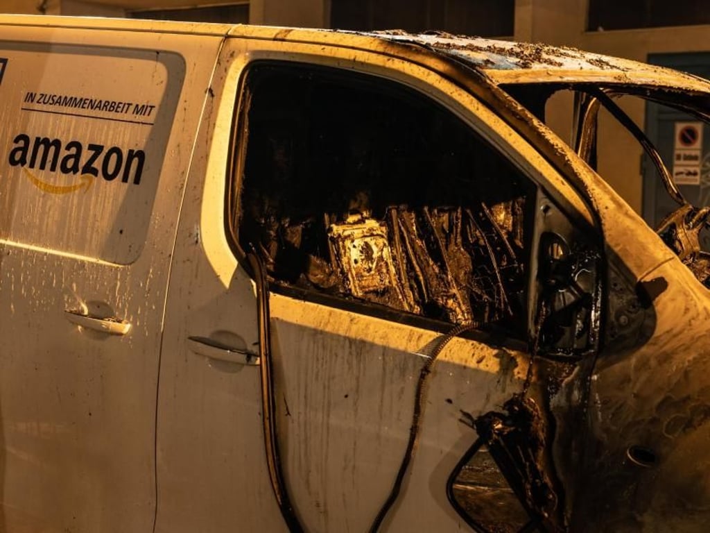 Ein ausgebranntes Lieferfahrzeug mit dem Logo des Onlineversandhändlers Amazon. Foto: Paul Zinken