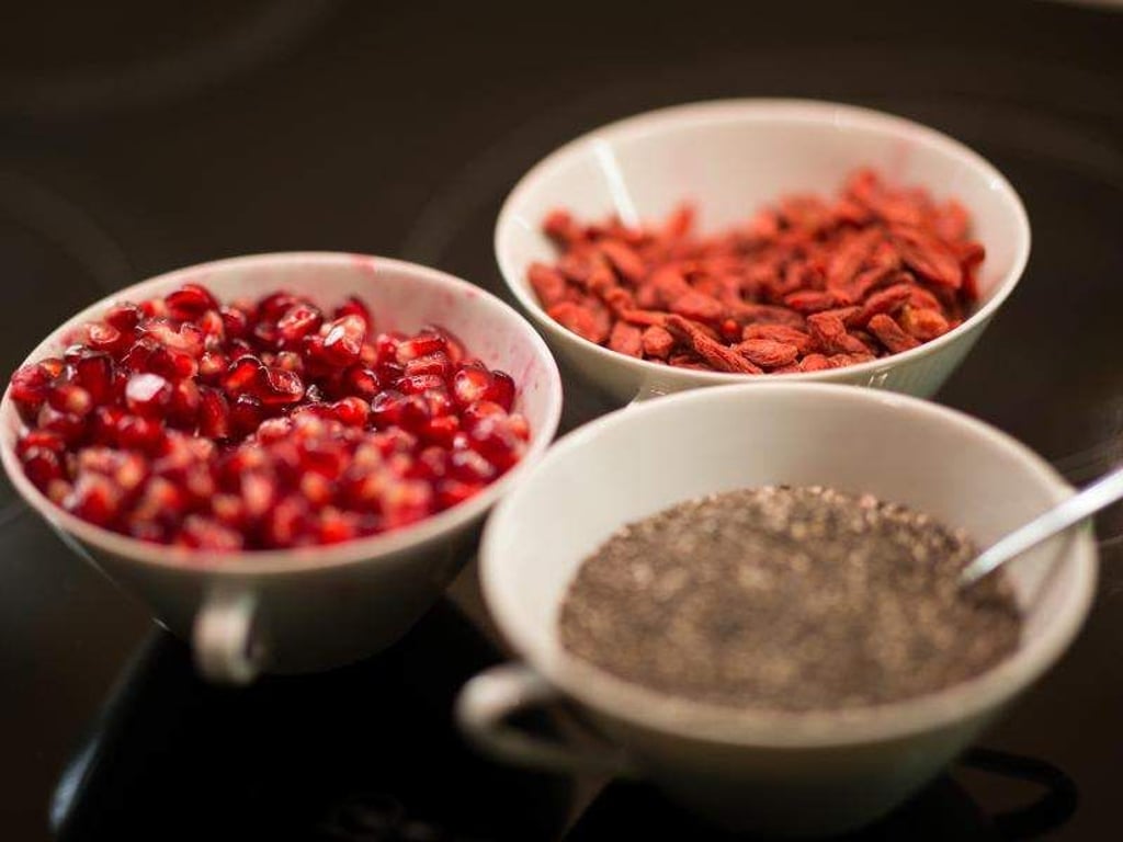 Chiasamen (unten r), getrocknete Gojibeeren und Granatapfelkerne (l) in Schüsseln. Foto: Mohssen Assanimoghaddam/Illustration