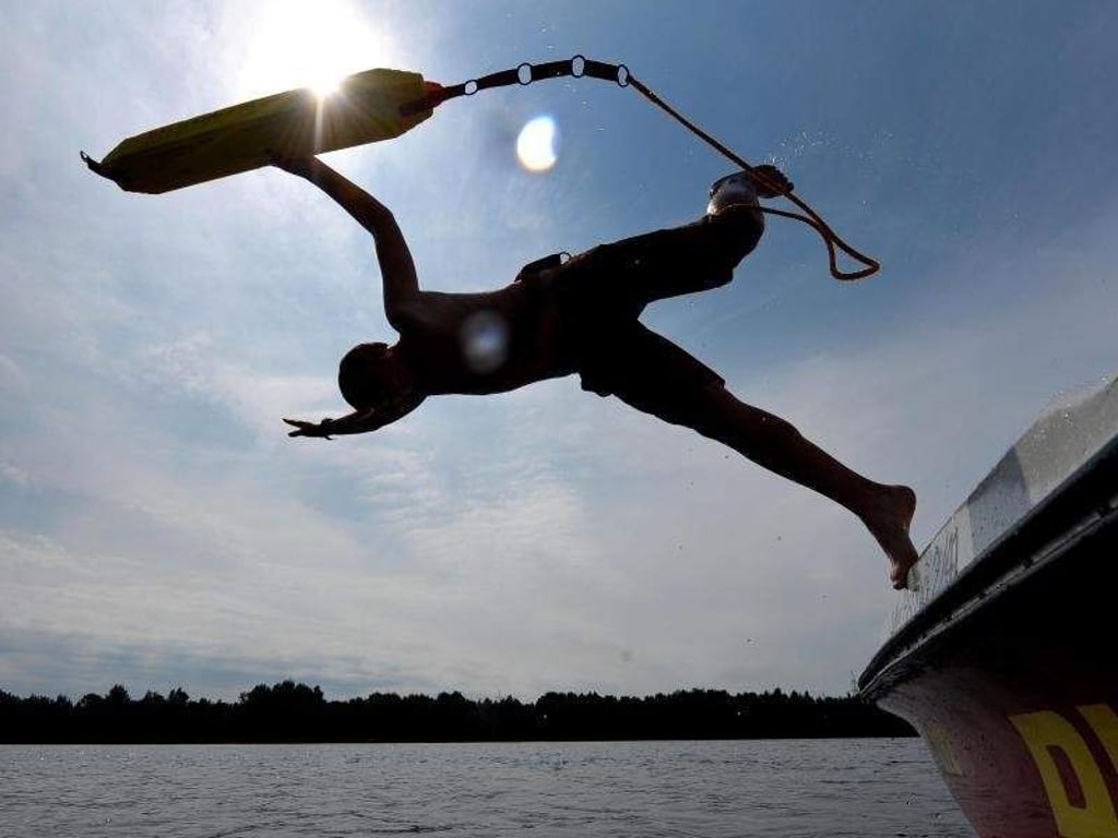 An vielen Seen im Einsatz: Ein Rettungsschwimmer springt ins Wasser. Foto: Peter Steffen/dpa