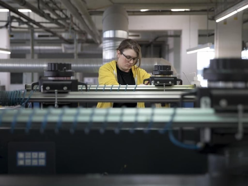 Frische Farbe: Hier wechselt Auszubildende Viviane Brummerhoff gerade die Kartusche einer Offset-Druckmaschine. Foto: Florian Schuh/dpa-tmn