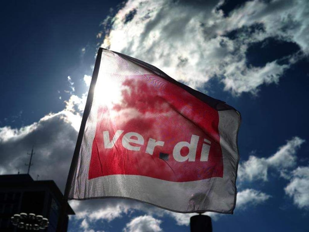 Eine Fahne von Verdi weht während einer Kundgebung im Wind. Foto: Ina Fassbender/Archiv