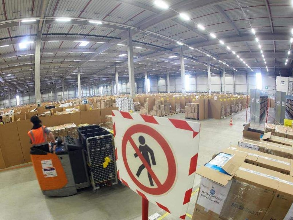 Ein Mitarbeiter des Amazon-Logistikzentrums stellt Waren für den Paketversand zusammen. Foto: Thomas Frey/Illustration
