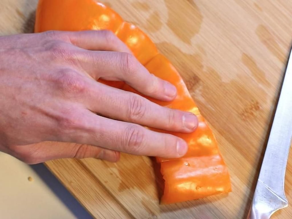 Schritt 5: Die entkernte Paprika kann man nun flach auf das Brett drücken und dann in Streifen oder Würfel schneiden. Foto: Karolin Krämer