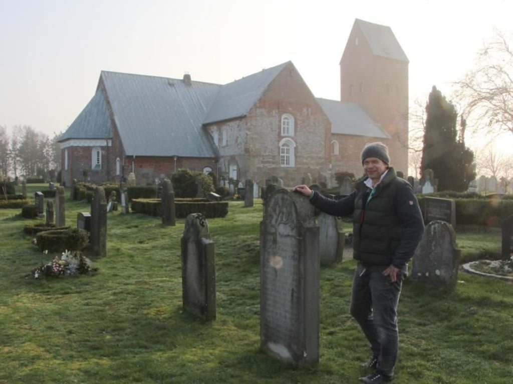 Steinmetz Markus Thiessen - hier an der Kirche St. Laurentii in Süderende - setzt auf der Insel Föhr die Tradition der «sprechenden Grabsteine» fort. Foto: Alexandra Frank