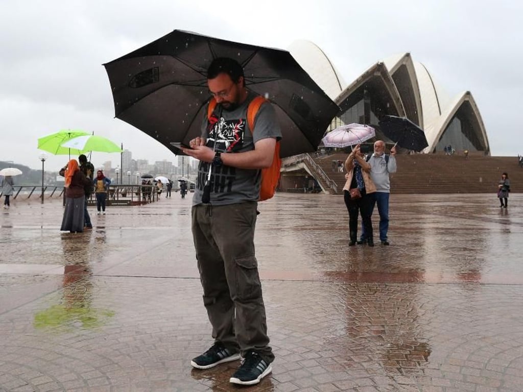 Im Regen vor dem Opernhaus in Sydney: Pokémon Go-Spieler. Foto: David Moir