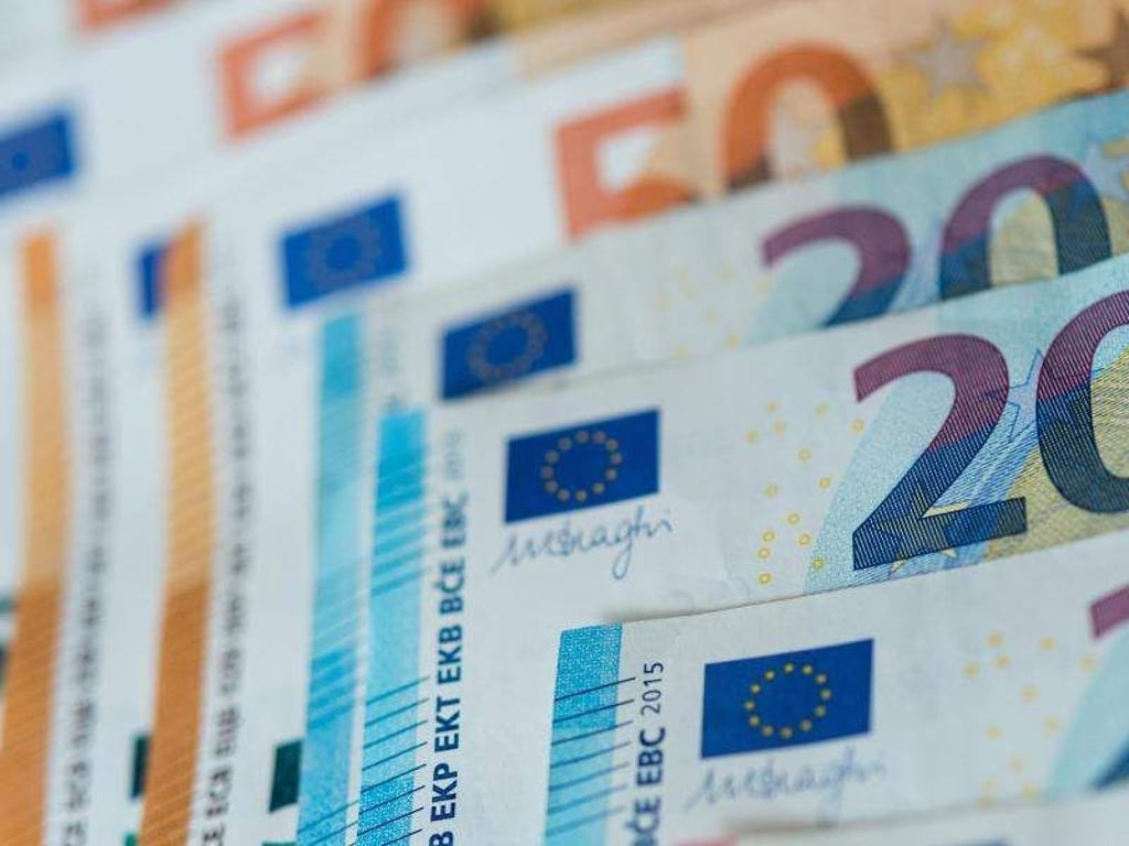 20 und 50 Euro-Banknoten liegen sortiert auf einem Tisch. Foto: Monika Skolimowska/Archivbild