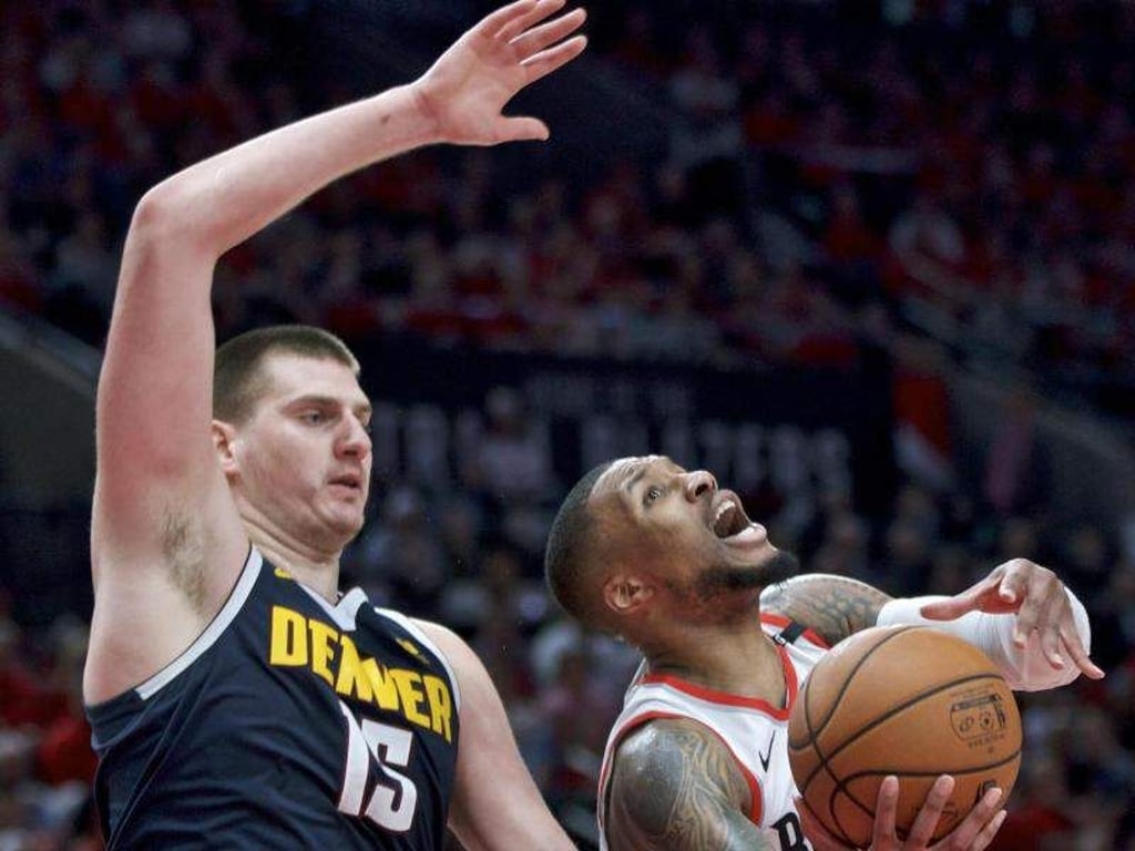 Damian Lillard (r) von den Portland Trail Blazers verteidigt gegen Nikola Jokic von den Denver Nuggets. Foto: Craig Mitchelldyer/AP