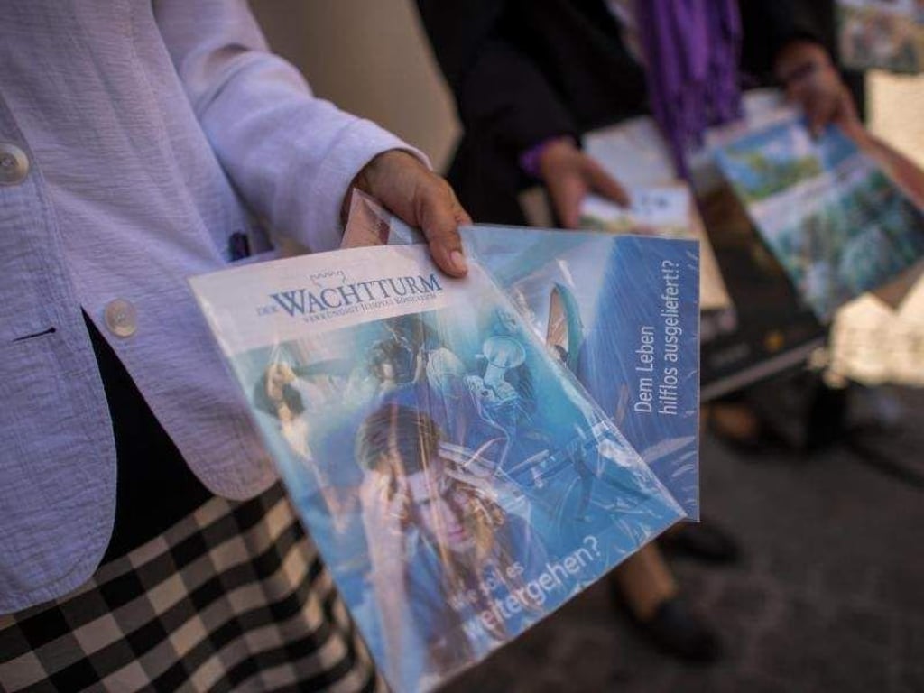 Zeugen Jehovas verteilen Hefte. Die Religionsgemeinschaft will eine Gleichstellung mit anderen Kirchen. Foto: Matthias Balk/Archiv