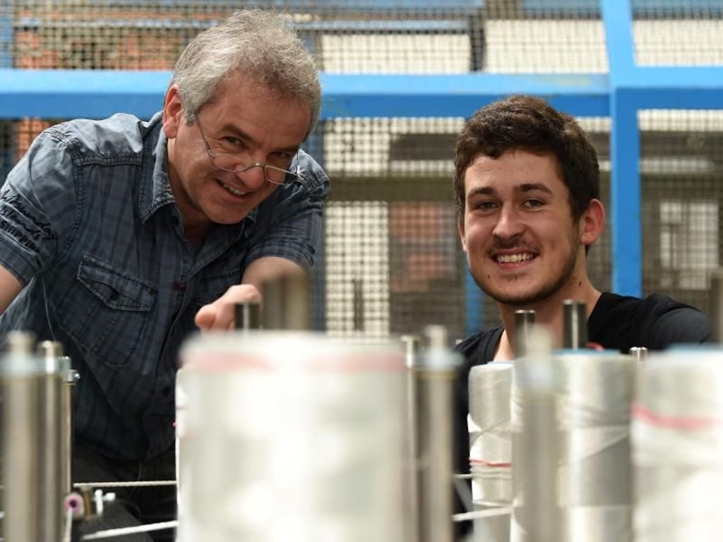 Ausbilder Wolfram Müller steht mit seinem Azubi Hendrik Borchardt (l) an einer Flechtmaschine. In Seilerbetrieben sind Maschinen ebenso wichtig wie die Handarbeit. Foto: Carmen Jaspersen