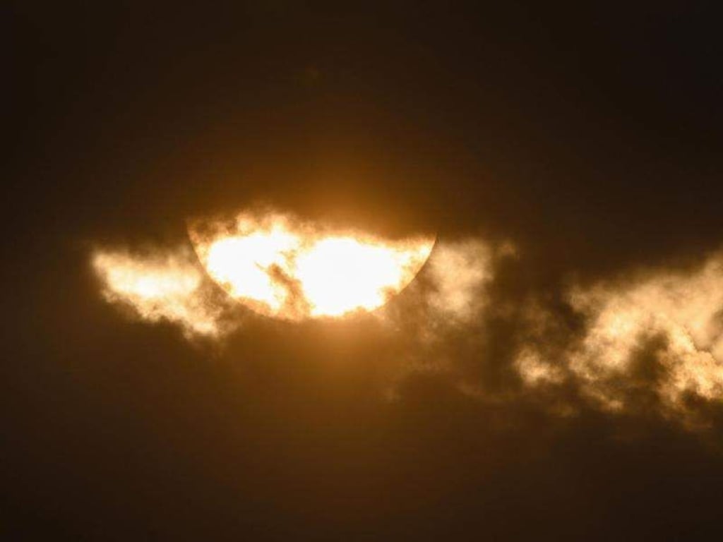 Die Sonne scheint durch Wolken hindurch. Foto: Christophe Gateau/Archivbild