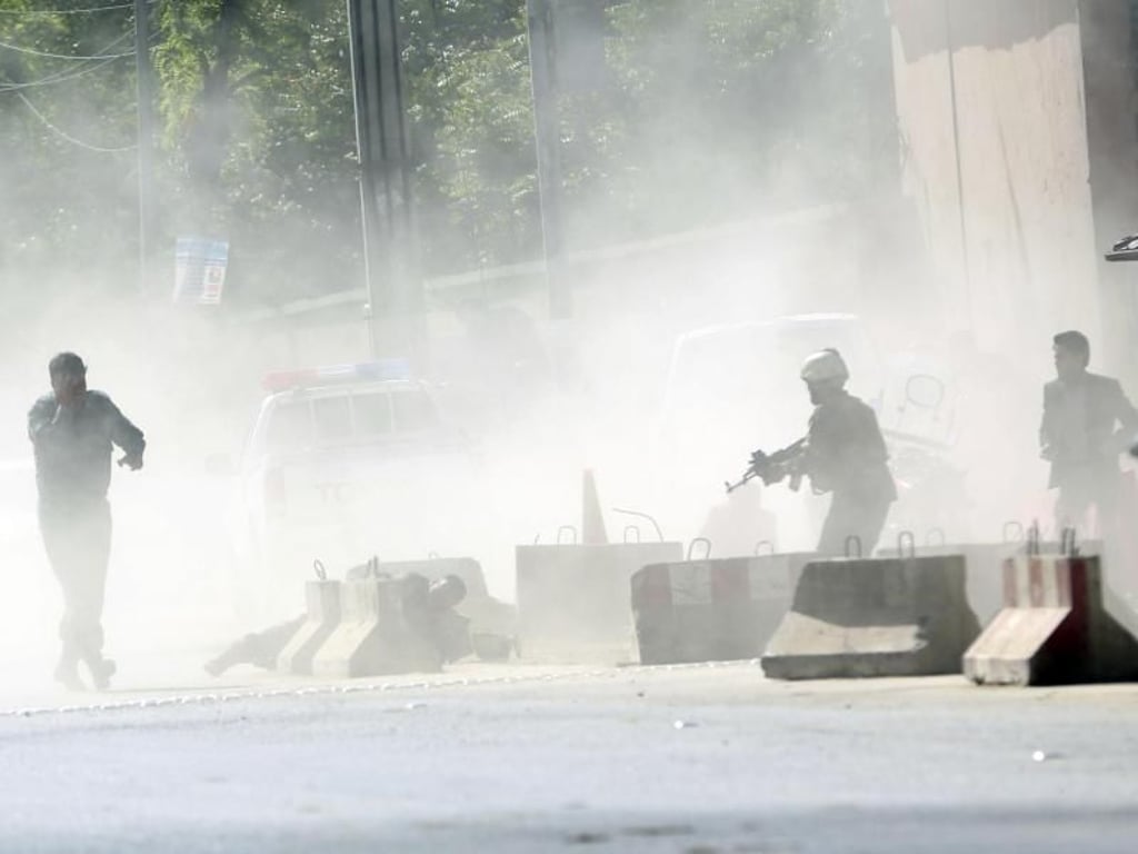 Sicherheitskräfte stehen nach einer Explosion in Kabul in einer Rauchwolke. Bei zwei Explosionen in der afghanischen Hauptstadt Kabul sind zahlreiche Menschen getötet worden. Foto: Massoud Hossaini