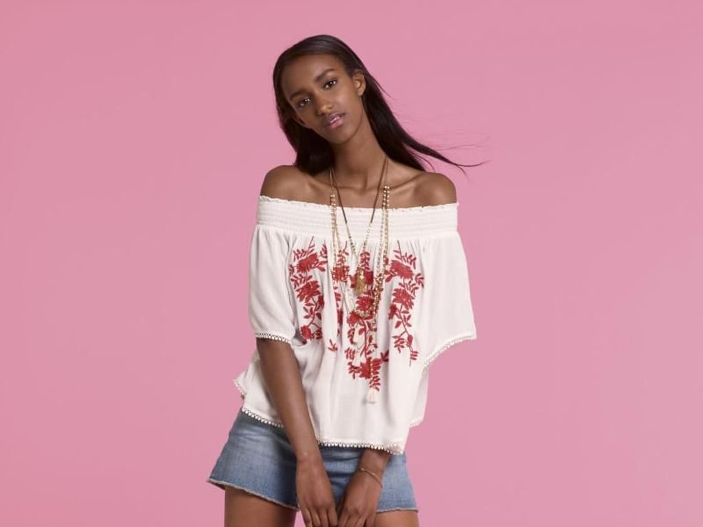 In der Freizeit lässt sich die Off-Shoulder-Bluse auch zu Shorts kombinieren (Bluse ca. 50 Euro, Shorts ca. 40 Euro, Tasche ca. 90 Euro, Schuhe ca. 60 Euro). Foto: United Colors of Benetton