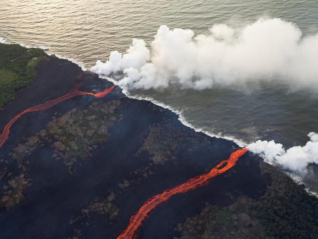 Seit Anfang Mai speit der Kilauea Lava aus dem Krater und aus Erdspalten, die hier ins Meer fließt. Foto: Bruce Omori/Paradise Helicopters