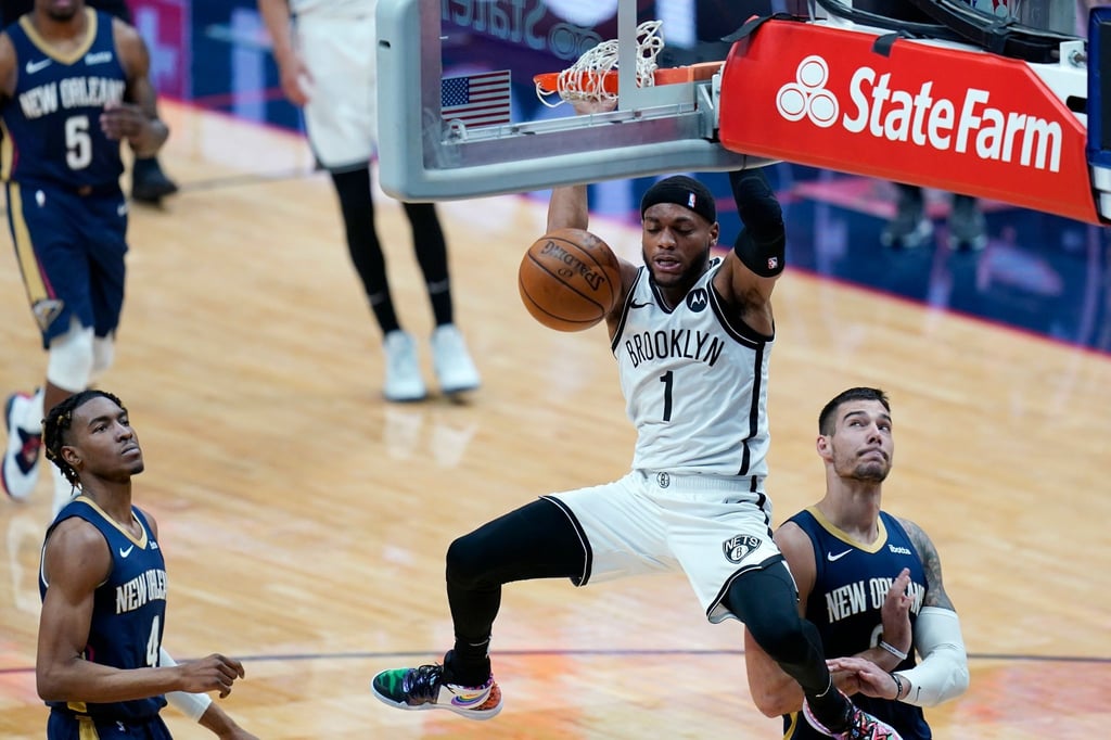 Bruce Brown (M) von den Brooklyn Nets macht einen Slam Dunk über Wes Iwundu (l) und Willy Hernangomez von den New Orleans Pelicans.
