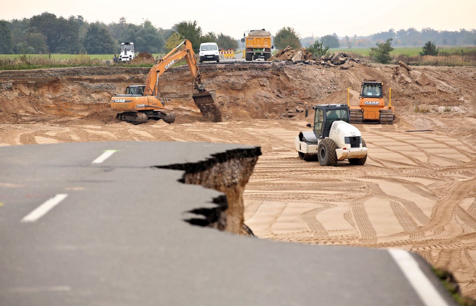 Bauarbeiter bereiten die Reparatur der vom Hochwasser der Mulde zerstörten Staatsstraße zwischen Löbnitz und Pouch vor.