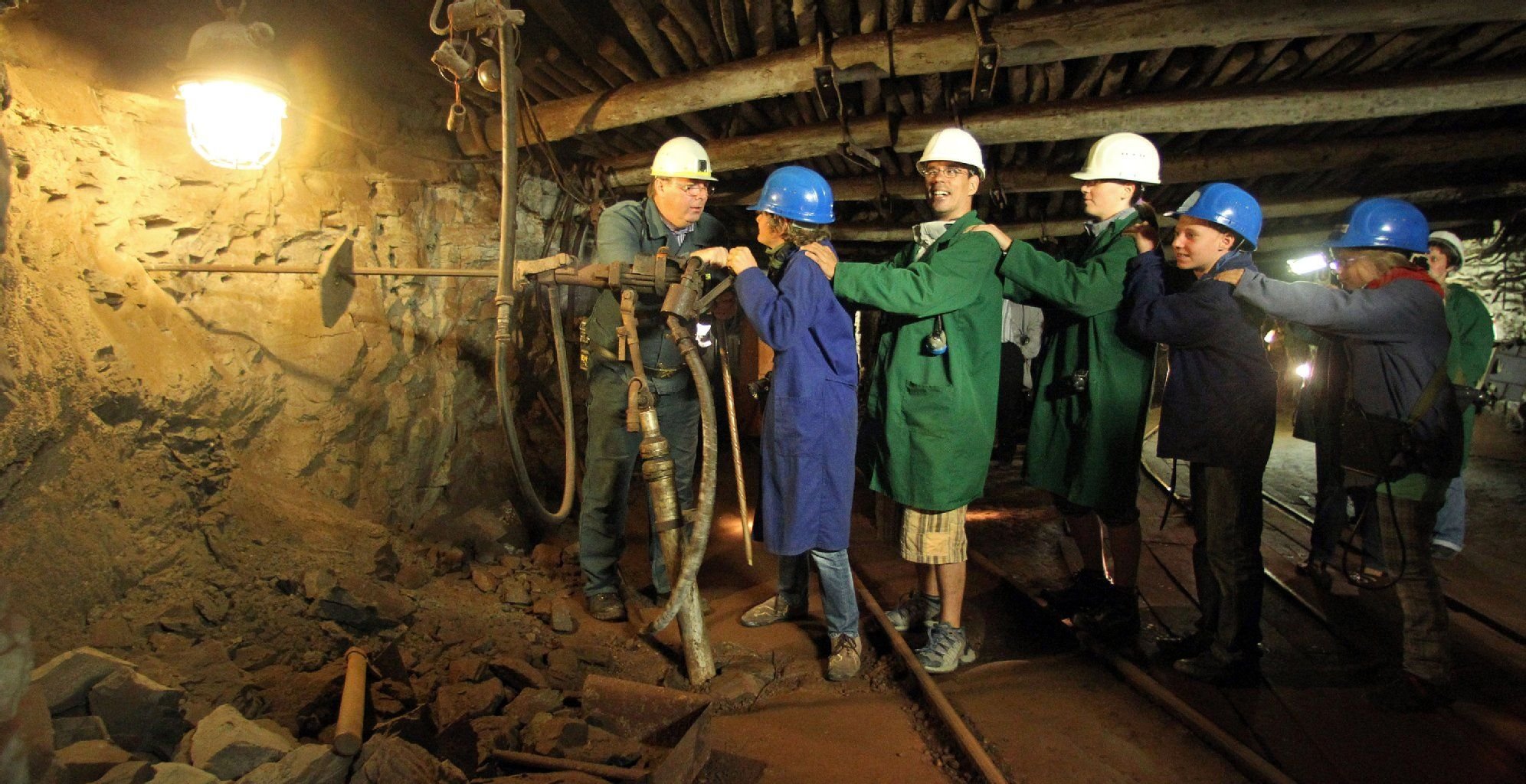 Besucher versuchen sich an einem schweren Pressluftmeißel im Schaubergwerk «Röhrigschacht» in Wettelrode (Sachsen-Anhalt).