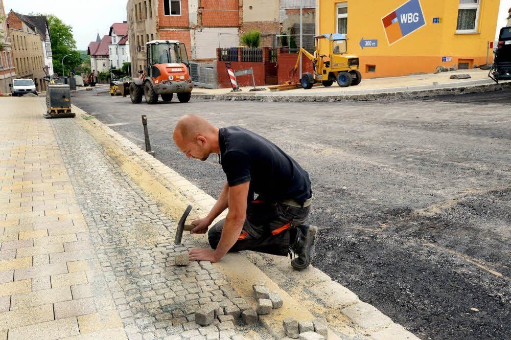 Das sieht schon gut aus: Stephan Hofmann von Straßen- und Tiefbau GmbH Osterfeld pflastert noch den Sicherheitsstreifen am Gehweg.