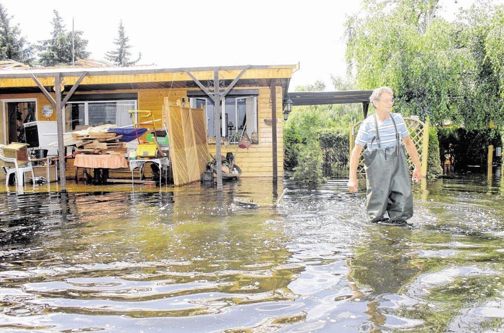 Günter Kniestedt aus Köthen schaut sich am 24. Juni sein überflutetes Grundstück am Löbitzsee an. Das Wasser ist inzwischen etwas zurückgegangen, steht aber immer noch kniehoch.