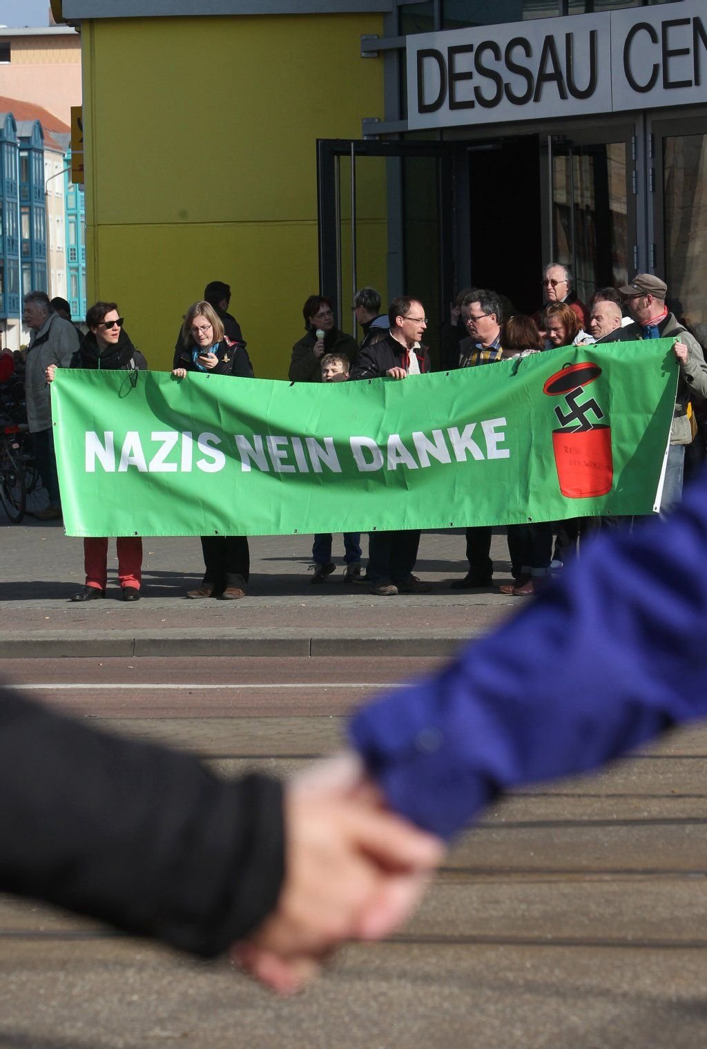 Teilnehmer einer Menschenkette stehen mit einem Transparent in Dessau-Roßlau.