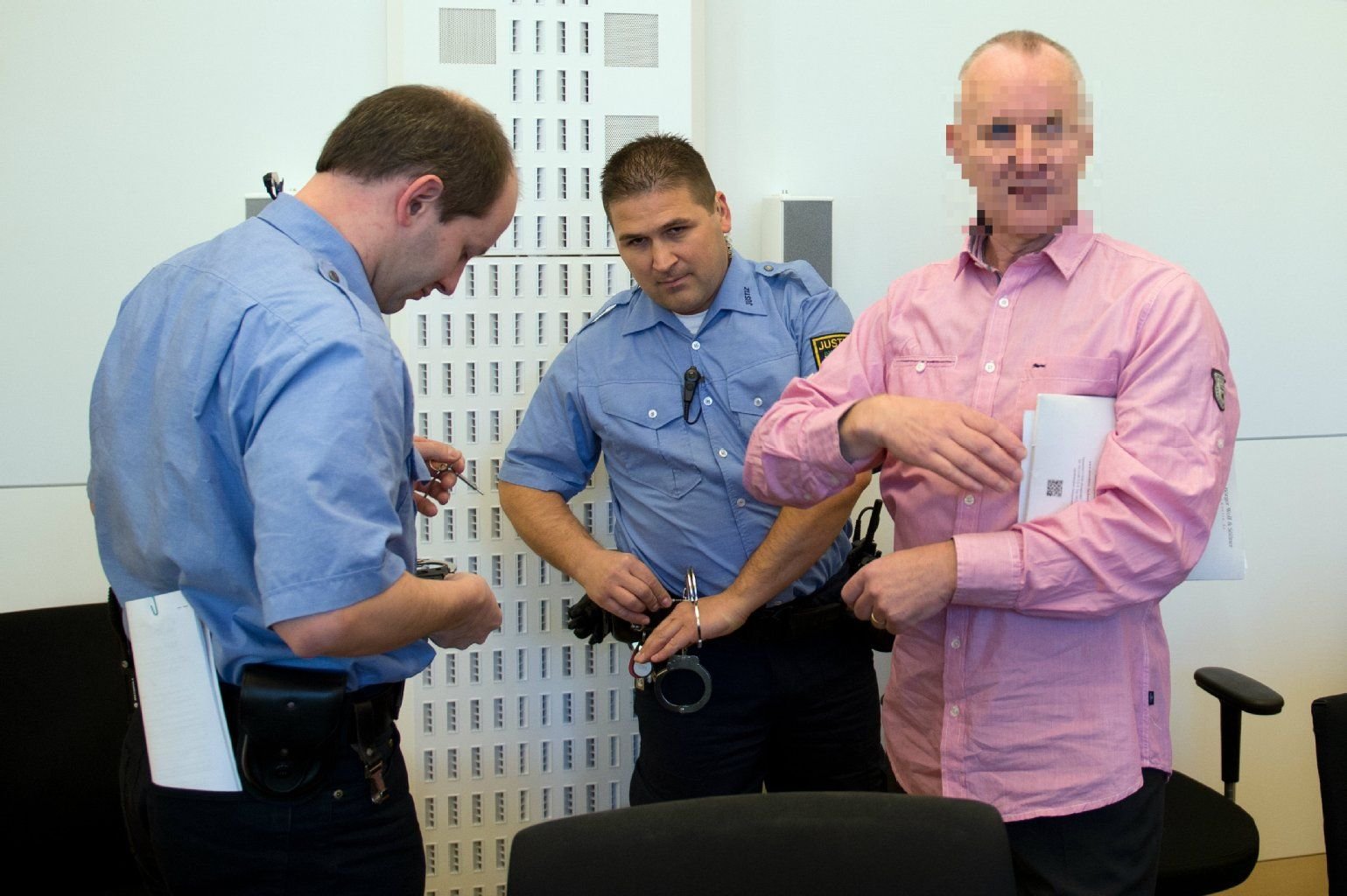 Der Angeklagte Detlev G. (re.) wird am Landgericht in Dresden von zwei Mitarbeitern der Justiz zur Fortsetzung seines Prozesses in den Gerichtssaal geführt.