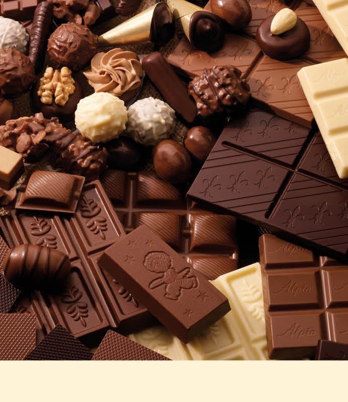 Pralinen und Schokoladentafeln liegen auf einem Stapel.