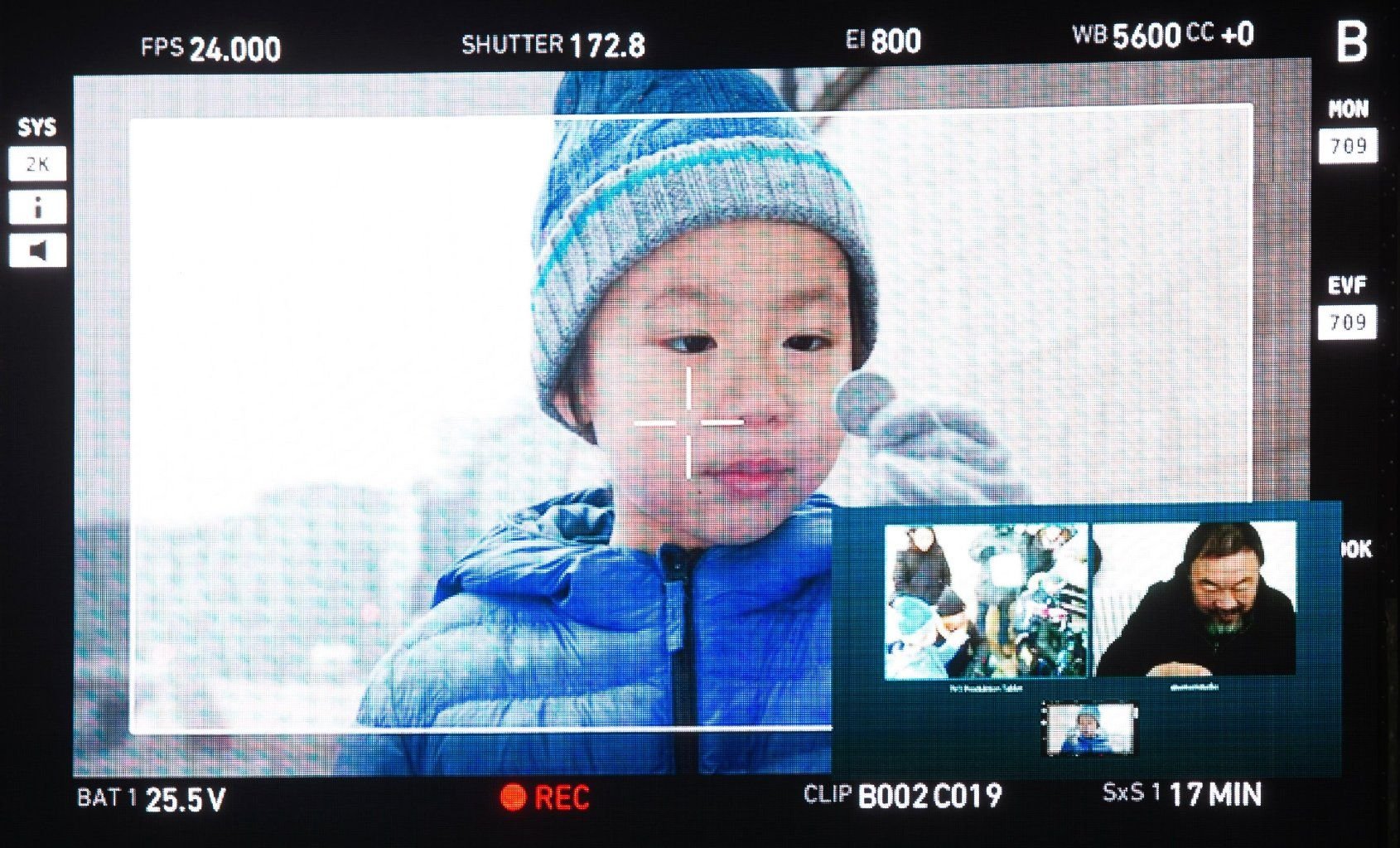 Ai Lao (l) und sein Vater, der chinesische Konzeptkünstler Ai Weiwei, sind bei Dreharbeiten für den Film "Ai Weiwei" am 07.02.2015 in Berlin während der 65. Internationalen Filmfestspiele auf einer Leinwand am Potsdamer Platz zu sehen.