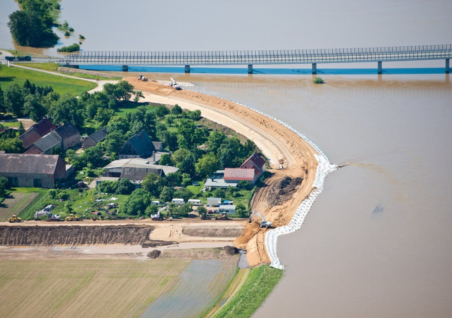Während in Mühlberg (Kreis Elbe-Elster) ein neuer Deich gebaut wird, steht das Hochwasser der Elbe an der Deichoberkante.