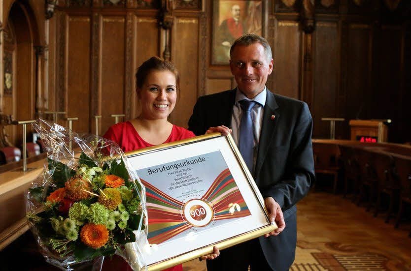 Sarah Tkotsch erhält aus den Händen von Köthens OB Kurt-Jürgen Zander die Ernennungsurkunde als Jubiläums-Botschafterin.