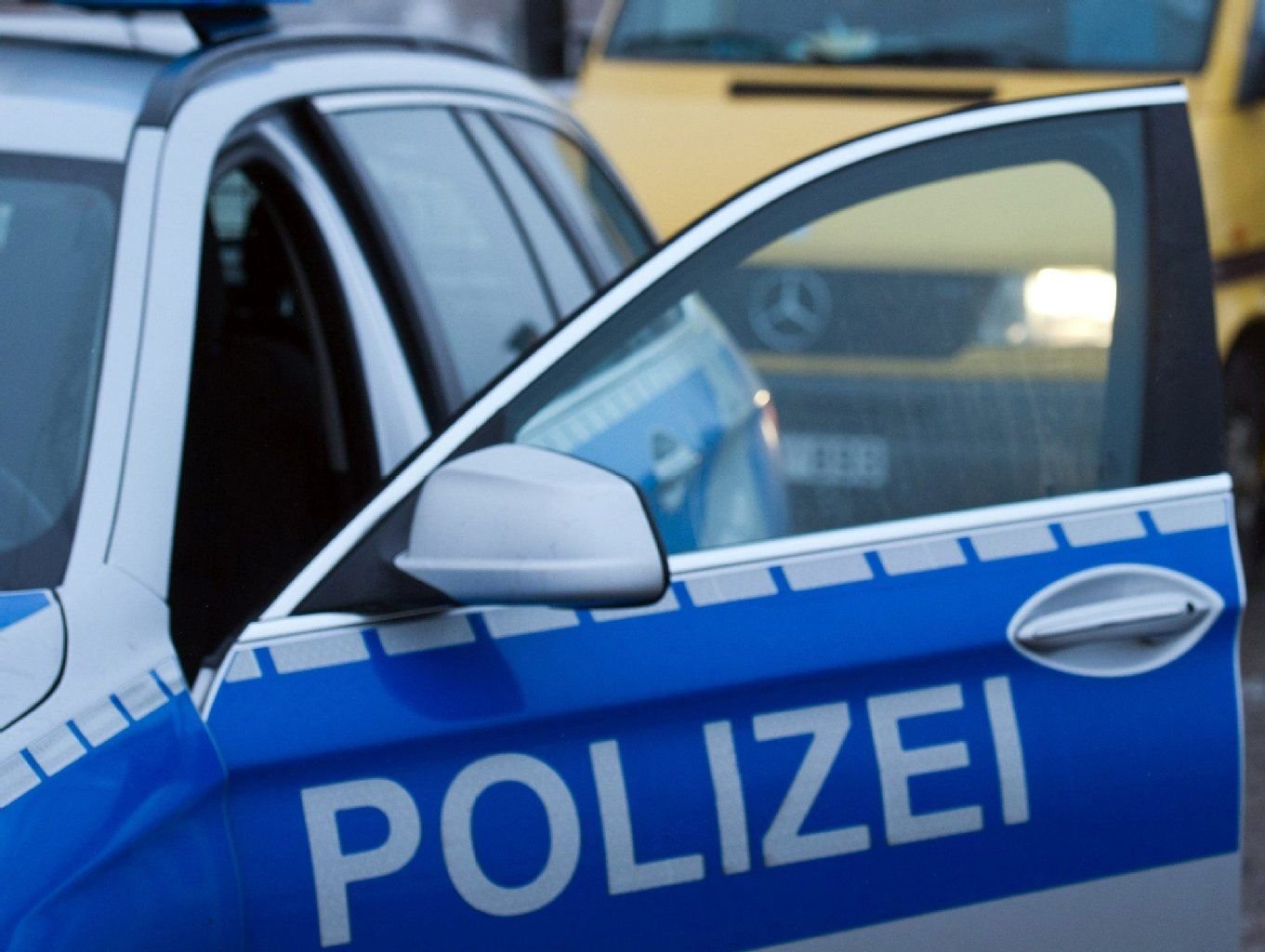 Die Tür eines Streifenwagen der Polizei steht offen.