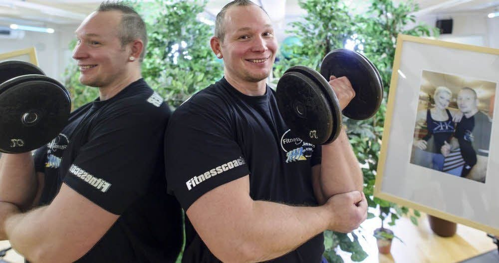 Dschungelatmosphäre im Fitness-Studio. Trainer Marco Lautenschläger posiert vor einem Spiegel mit Hantel und dem Bild von Melanie Müller.