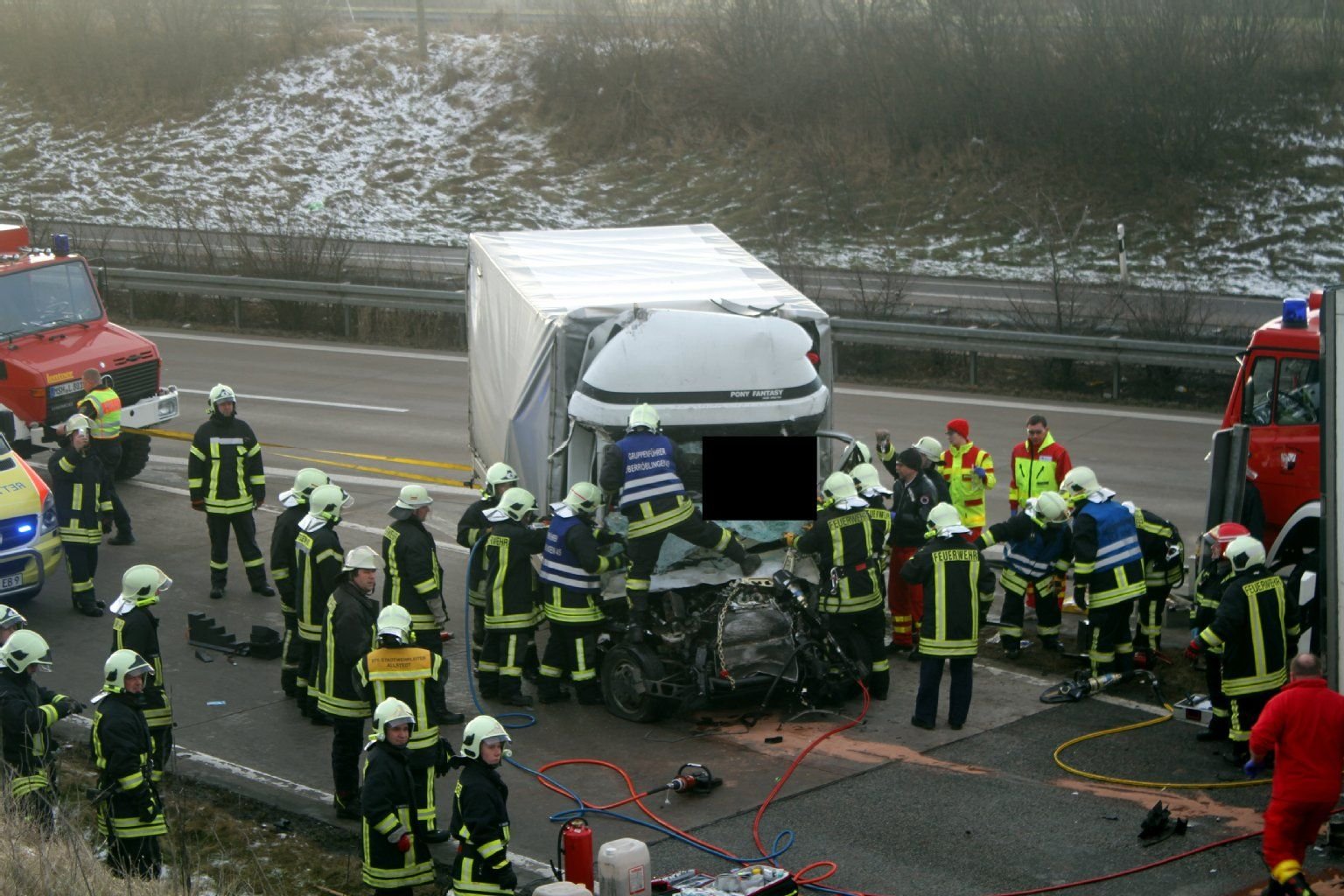 Feuerwehrleute versuchen, den eingeklemmten Lkw-Fahrer zu retten.