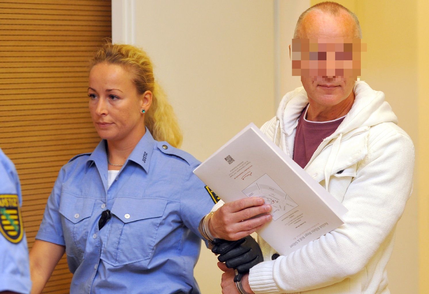Justizbeamte führen am 22.08.2014 in Dresden im Landgericht den Angeklagten Detlev G. (r) in den Saal.