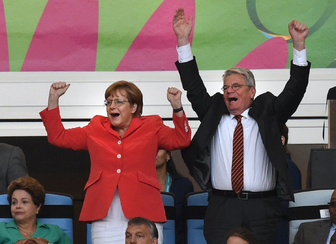 Kanzlern Merkel jubelt mit Joachim Gauck zum 1:0 der deutschen Mannschaft. Die modischen Statements: Kette, Tasche und Krawatte.
