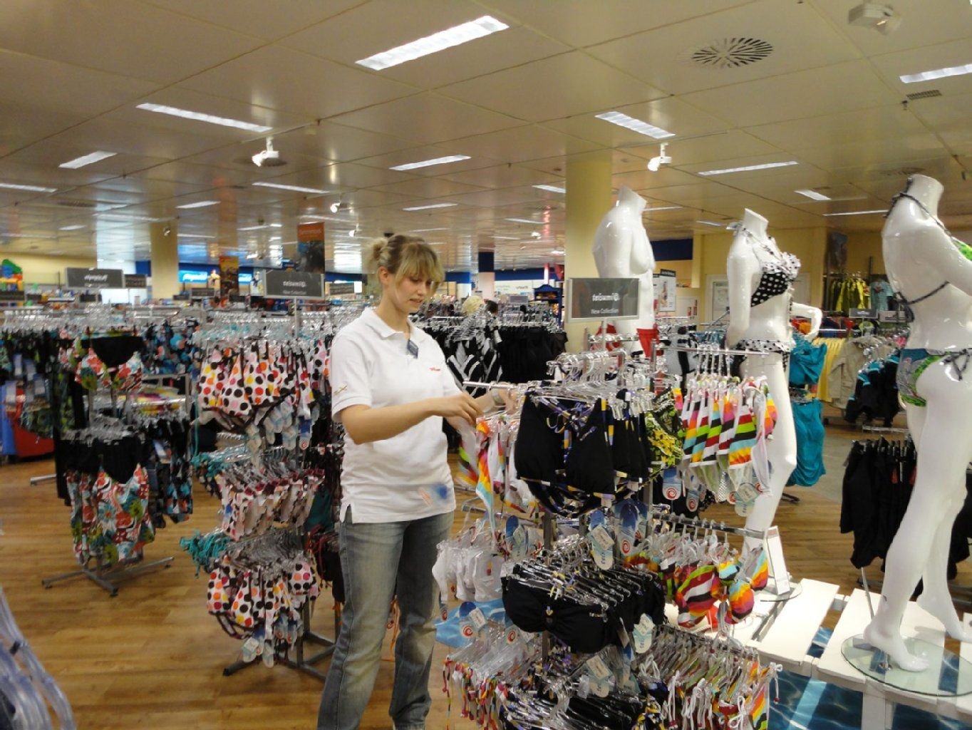Eine Karstadt-Mitarbeiterin sortiert in der Filiale in Dessau-Roßlau Badebekleidung.