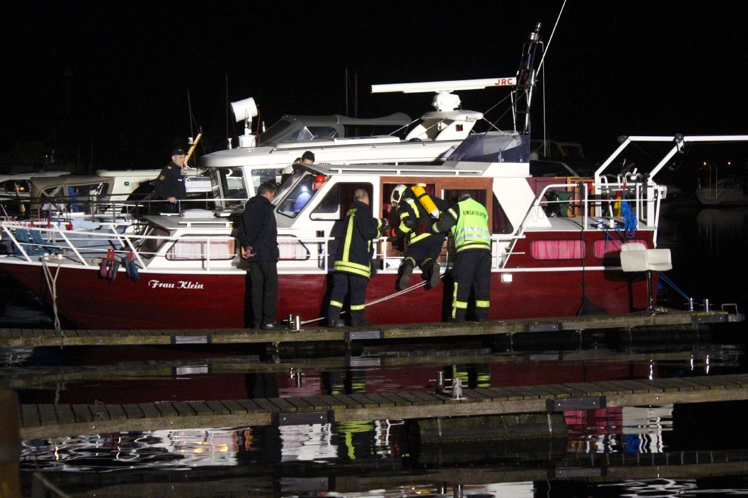 Feuerwehrmänner mit Atemschutz buntersuchen das Boot.