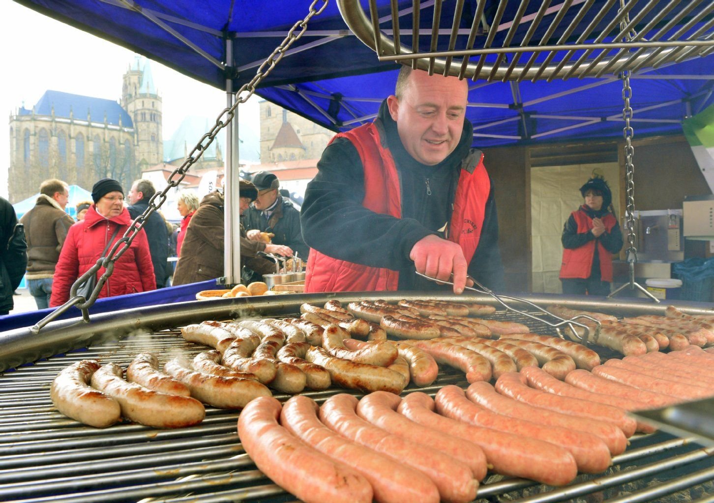 Bratwürste liegen am 23. März auf dem Domplatz in Erfurt auf dem Grill von Joachim Stumpf aus Gernrode.